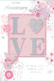Blush-pink anniversary card with tactile LOVE motif and delicate floral swirls, echoing the romance of Ealing's leafy streets. The card is presented flat, filling the frame with a soft, dreamy palette of blush, ivory white, muted grey, and twinkling silver accents. At its core, the word LOVE is rendered in bold, raised letters that glimmer with a fine layer of glitter, giving the impression of soft frost on petals. The texture appears inviting and slightly grainy, suggesting that running a fingertip across it would feel like touching a luxuriously embellished gift tag on a special anniversary bouquet. Around this central word, delicate illustrated flowers, curling leaves, and graceful tendrils spread outwards, their lines so fine they resemble ink drawings rather than heavy print. The blossoms are light and airy, mostly in soft pink and white, with subtle silver touches that catch the eye like tiny dewdrops. A smooth pink background wraps everything in warmth, mirroring the colour of early cherry blossoms near Walpole Park. A heartfelt anniversary message in elegant script is woven into the design, its gentle curves harmonising with the floral scrolls. The overall mood is serene and romantic, suggesting shared memories and quiet celebrations at home in Ealing. The card feels thoughtfully composed, much like a hand-crafted arrangement ready for local delivery, conveying love that is both gentle and enduring.